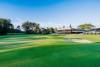 Shoalhaven Heads Golf Club fairway and bunker with the clubhouse in the background on a sunny day.